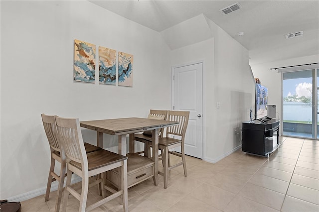 dining space with a textured ceiling and light tile patterned floors