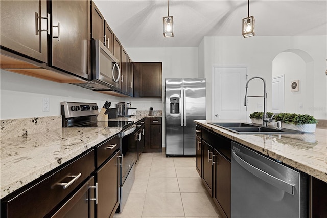 kitchen with appliances with stainless steel finishes, sink, dark brown cabinets, and pendant lighting