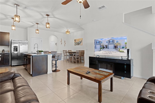 tiled living room featuring ceiling fan and sink