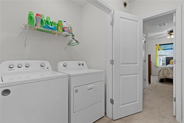 washroom featuring light carpet, washing machine and dryer, and ceiling fan