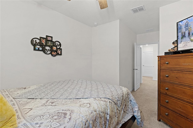 carpeted bedroom featuring a textured ceiling and ceiling fan