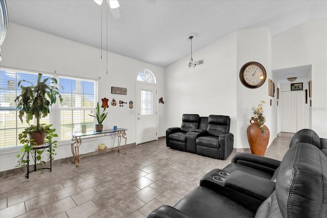 tiled living room featuring ceiling fan and high vaulted ceiling