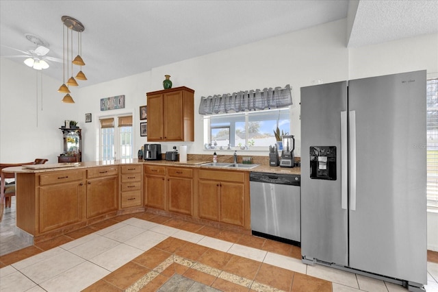 kitchen featuring pendant lighting, stainless steel appliances, sink, kitchen peninsula, and light tile patterned floors