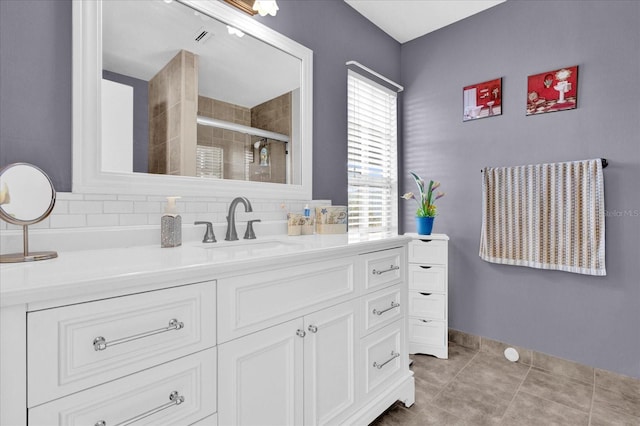 bathroom featuring decorative backsplash, tile patterned floors, vanity, and walk in shower