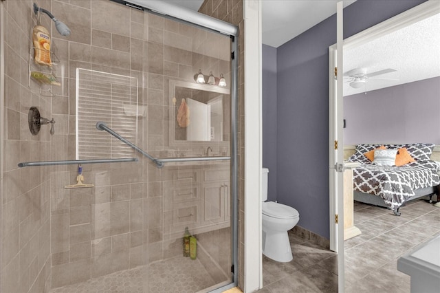 bathroom featuring ceiling fan, toilet, walk in shower, and a textured ceiling