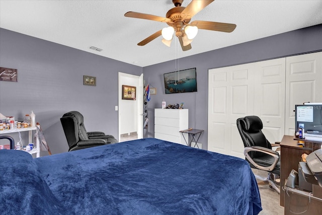 bedroom with a textured ceiling, ceiling fan, and a closet