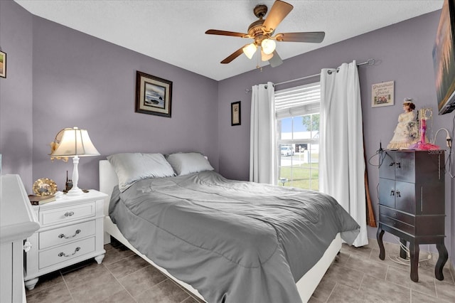 bedroom with ceiling fan and a textured ceiling