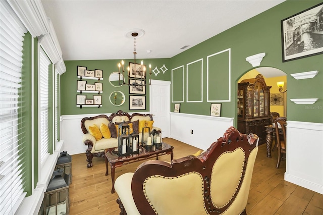 living area featuring a chandelier, vaulted ceiling, and light hardwood / wood-style floors