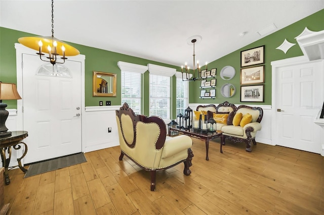 sitting room featuring lofted ceiling, light hardwood / wood-style flooring, and a notable chandelier