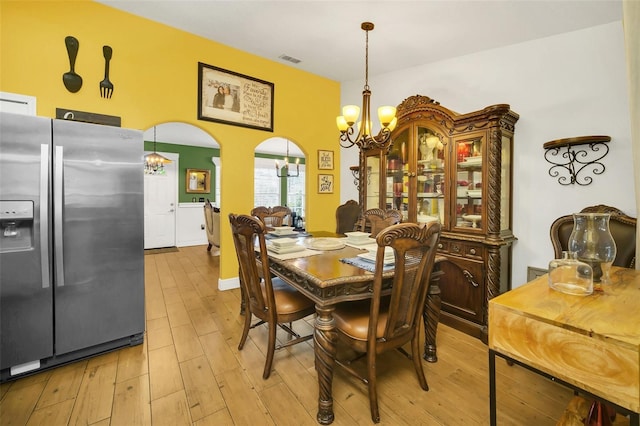 dining room featuring light hardwood / wood-style flooring and an inviting chandelier