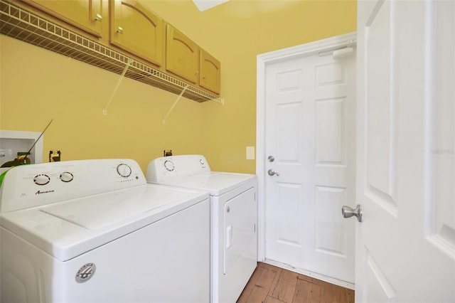 laundry area with cabinets, dark hardwood / wood-style floors, and separate washer and dryer