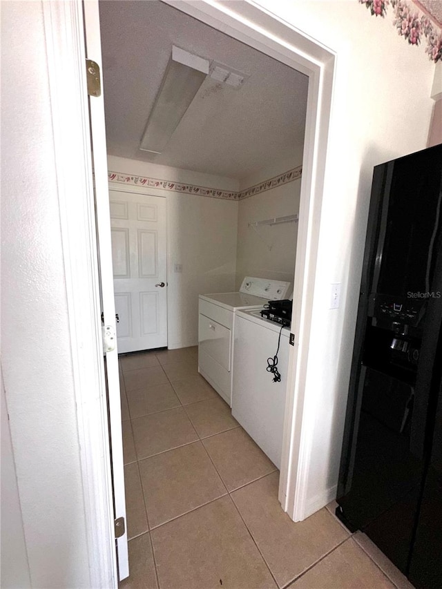 laundry room with light tile patterned floors and washer and clothes dryer