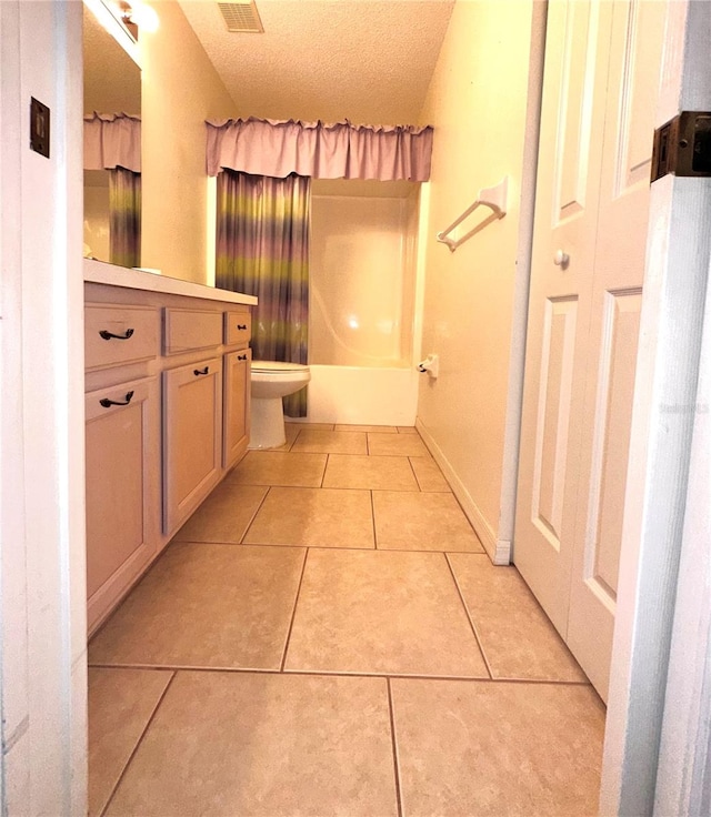 full bathroom featuring vanity, toilet, tile patterned floors, a textured ceiling, and shower / bath combo with shower curtain