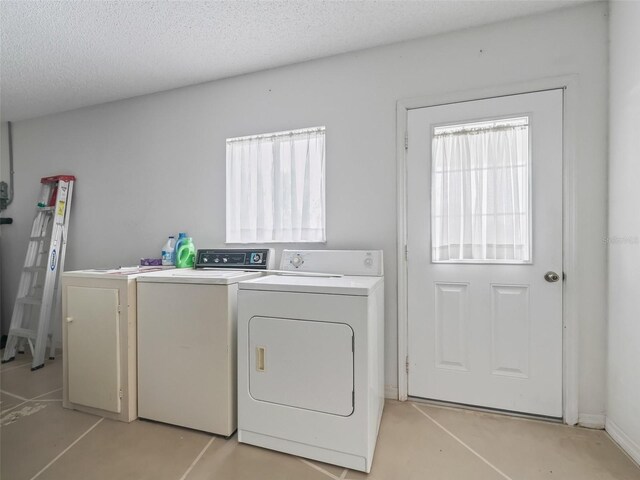 washroom featuring a textured ceiling and washer and clothes dryer