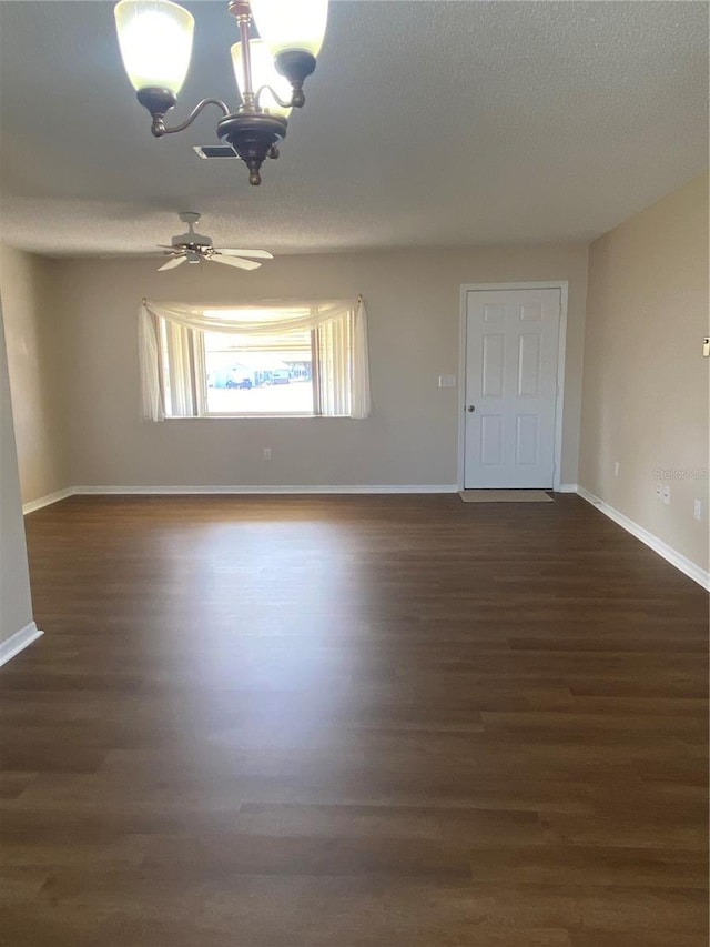 unfurnished room featuring a textured ceiling, ceiling fan with notable chandelier, and dark hardwood / wood-style floors