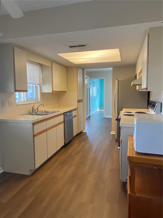 kitchen featuring stainless steel dishwasher, sink, white cabinetry, light wood-type flooring, and a textured ceiling