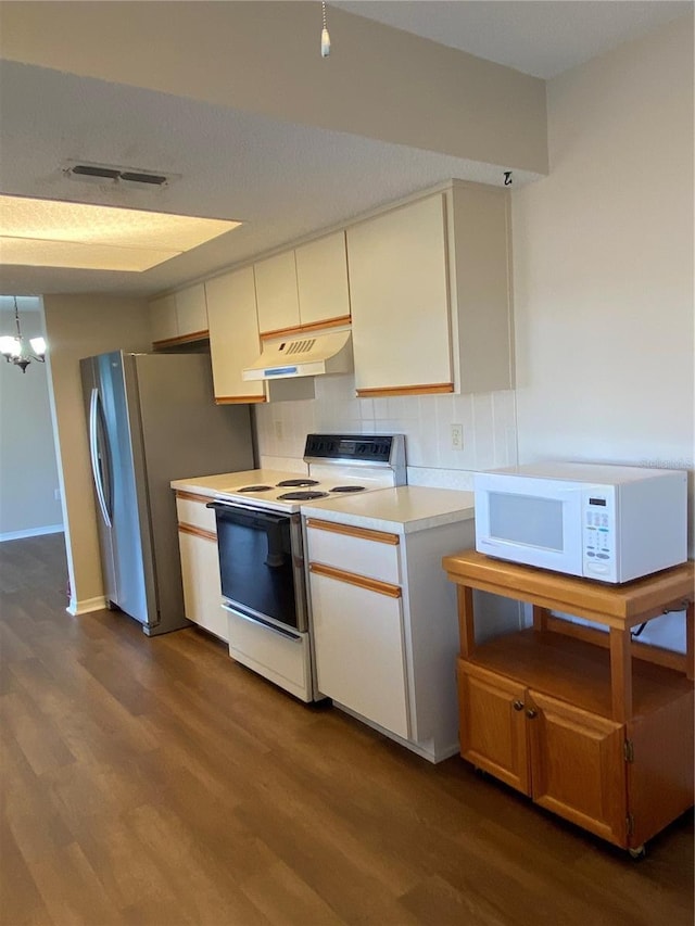 kitchen featuring decorative backsplash, white appliances, dark hardwood / wood-style flooring, and a chandelier