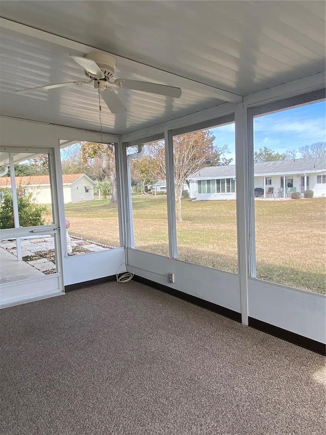 unfurnished sunroom with ceiling fan