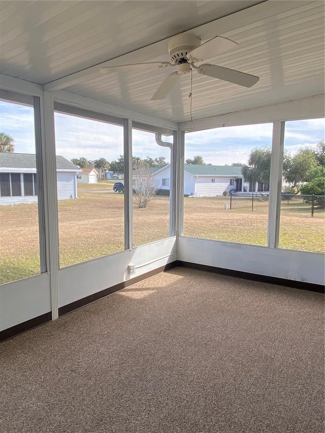 unfurnished sunroom with ceiling fan and a wealth of natural light