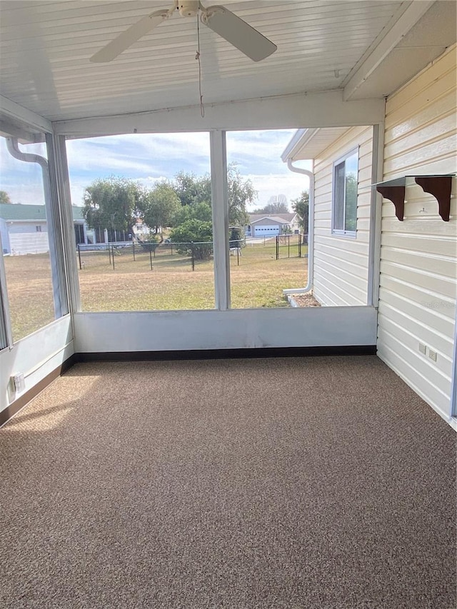 unfurnished sunroom featuring ceiling fan