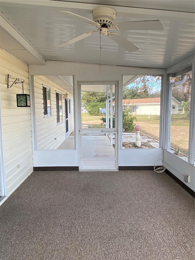 unfurnished sunroom featuring ceiling fan