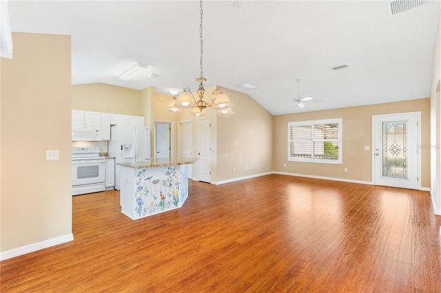 kitchen with white appliances, lofted ceiling, ceiling fan with notable chandelier, decorative light fixtures, and white cabinetry