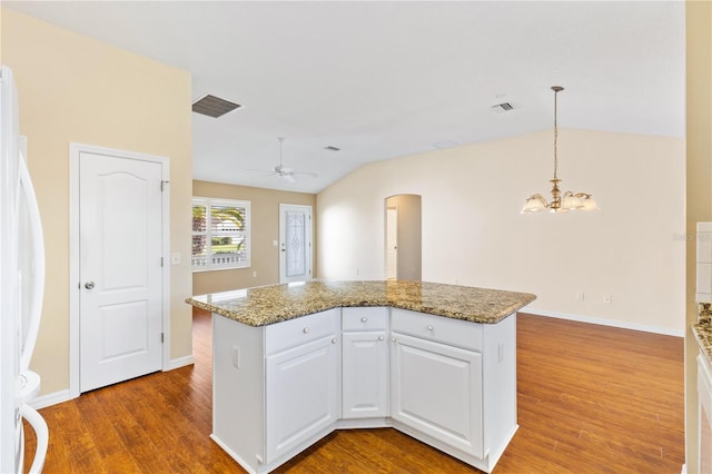 kitchen with white cabinetry, hanging light fixtures, white fridge, lofted ceiling, and ceiling fan with notable chandelier