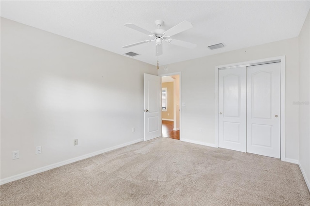 unfurnished bedroom with carpet, ceiling fan, and a closet