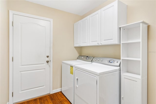 laundry room featuring washer and clothes dryer, dark hardwood / wood-style floors, and cabinets