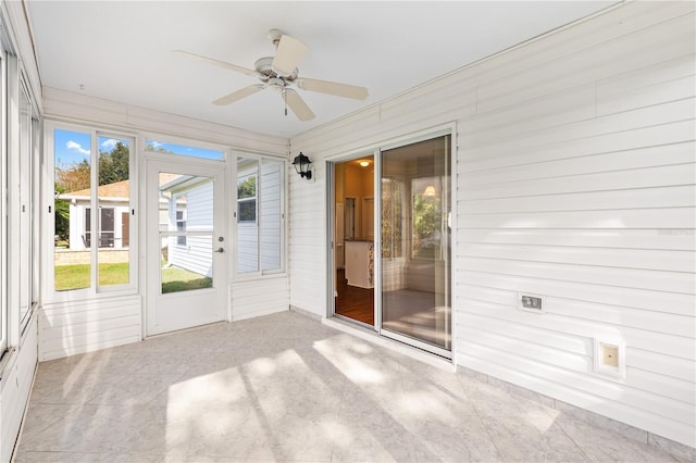 unfurnished sunroom featuring ceiling fan