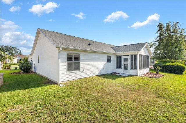 back of property with a sunroom and a yard