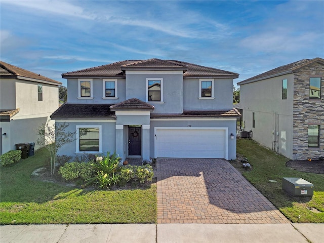 view of front of property featuring central air condition unit, a front lawn, and a garage