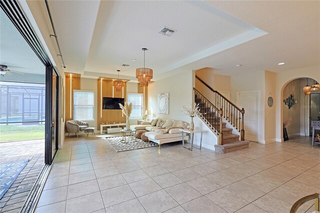 unfurnished living room with light tile patterned floors and ceiling fan with notable chandelier