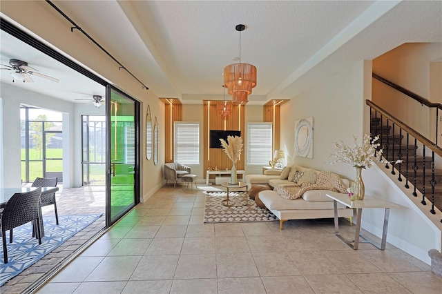 living room with ceiling fan, a textured ceiling, and light tile patterned floors