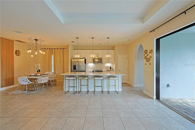 kitchen featuring a spacious island, appliances with stainless steel finishes, and decorative light fixtures