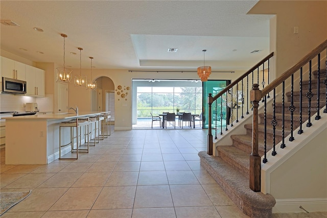 interior space with sink, a notable chandelier, a textured ceiling, and tile patterned flooring