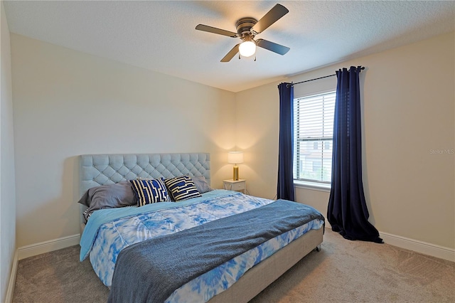 bedroom featuring ceiling fan, a textured ceiling, and carpet floors