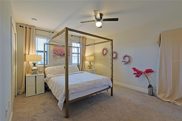 bedroom featuring a textured ceiling, carpet flooring, and ceiling fan