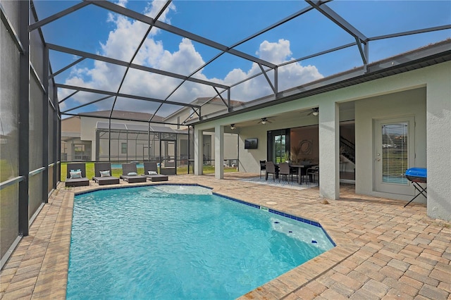 view of swimming pool featuring a patio, ceiling fan, and glass enclosure