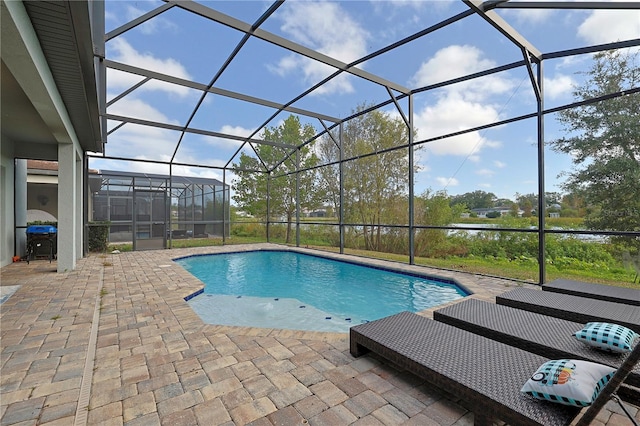 view of swimming pool featuring a patio and a lanai