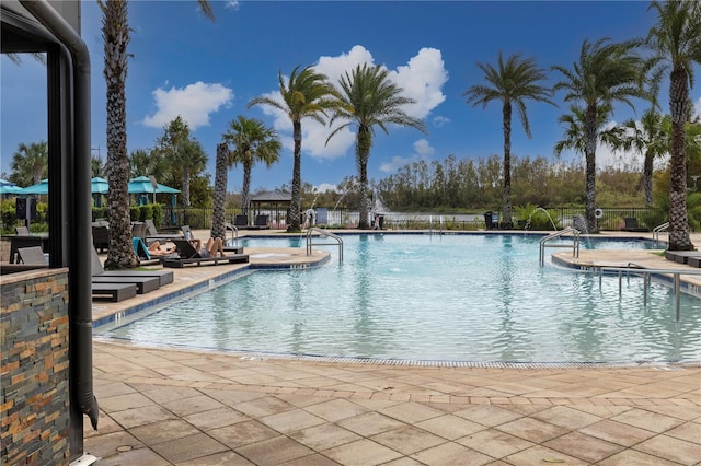 view of swimming pool with a hot tub and a patio area