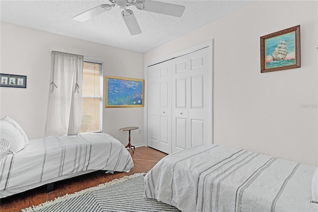 bedroom featuring a closet, ceiling fan, a textured ceiling, and dark hardwood / wood-style floors