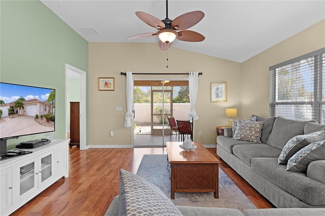 living room with ceiling fan, lofted ceiling, plenty of natural light, and hardwood / wood-style floors