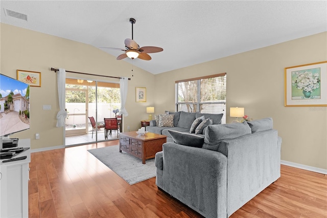 living room featuring ceiling fan, vaulted ceiling, light hardwood / wood-style flooring, and plenty of natural light