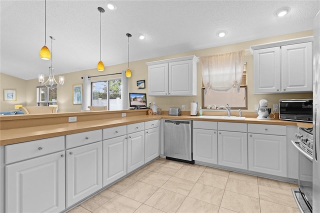 kitchen featuring white cabinetry, decorative light fixtures, and stainless steel appliances