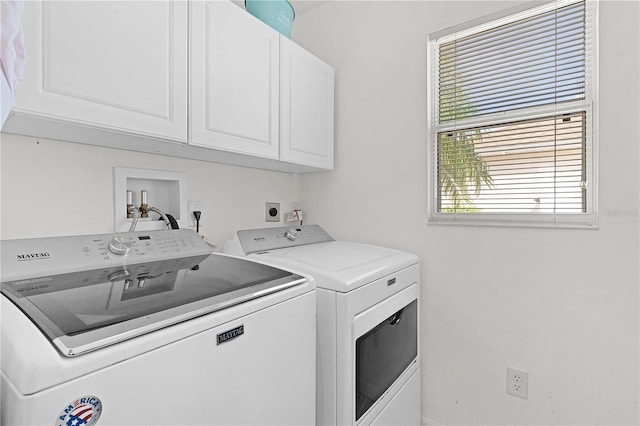 clothes washing area featuring cabinets and washing machine and clothes dryer