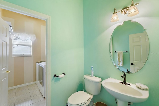 bathroom with toilet, sink, and tile patterned flooring