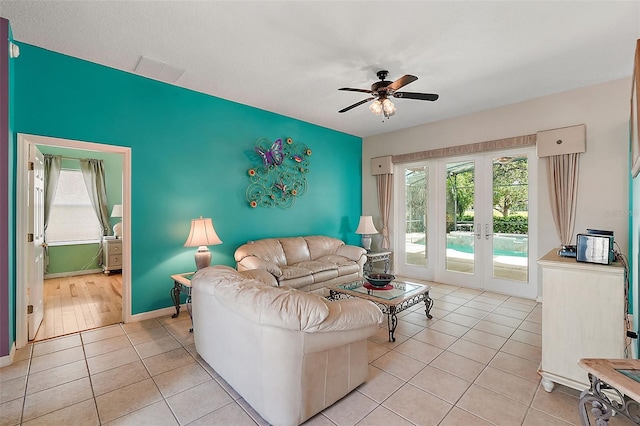 tiled living room with ceiling fan and french doors