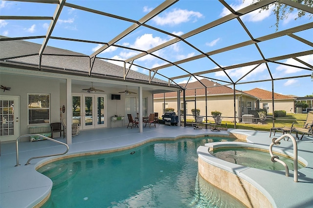 view of swimming pool with a lanai, an in ground hot tub, ceiling fan, and a patio