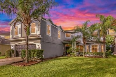 view of front of property with a garage and a lawn